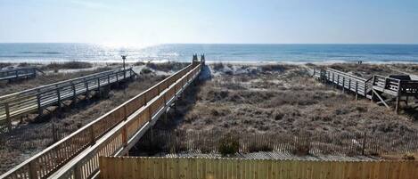 A wooden boardwalk leading to the beach with a clear view of the ocean.