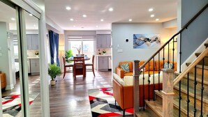 Un interior moderno con una escalera, un comedor y una cocina.