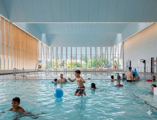 An indoor swimming pool with clear views of the outside, a high ceiling, and a modern architectural design. - Luxury 4BR Family Home, Private Fenced Yard, Near Toronto & Pearson (Mississauga)