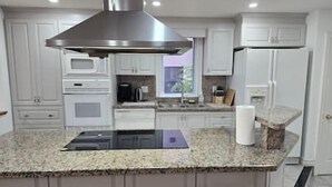 A modern kitchen with granite countertops, stainless steel appliances, and white cabinetry. - Luxury 3BR 3BA Family Home,  Walk to Lake, Toronto (Mississauga)