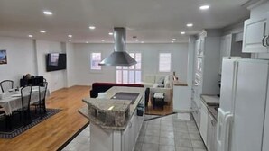 A spacious living area with a kitchen, dining table, and seating. - Luxury 3BR 3BA Family Home,  Walk to Lake, Toronto (Mississauga)