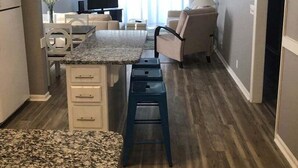 Un espacio habitable compacto con cocina, una mesa de comedor y una zona de estar con televisor.