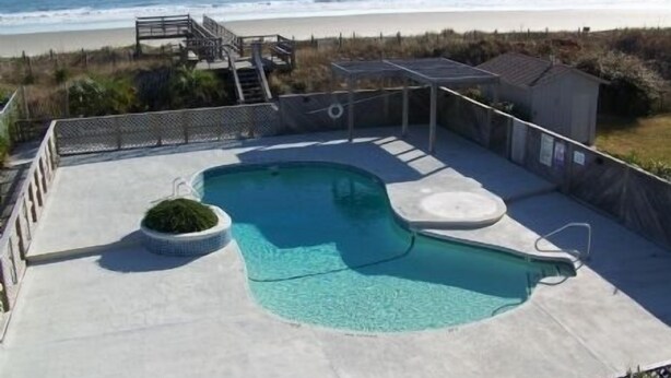 Una piscina con vista a la playa y al océano.