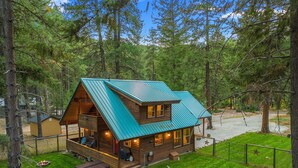A cabin with a metal roof, a deck, and a hammock. - Cozy cabin, dogs ok, hot tub, & fireplace (Leavenworth)