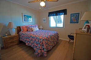 A bedroom with a bed, a nightstand, a dresser, a window with blinds, and a ceiling fan. - 3 br, 2 ba condo walking distance to beach (Ocean Isle Beach)