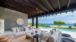 Ein stilvoller Lounge-Bereich mit einer Couch, einem Couchtisch und Meerblick.