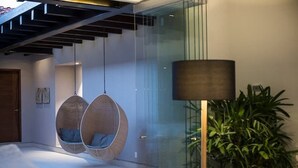 Ein modernes Interieur mit Hängestühlen, einer Lampe und einer Topfpflanze.