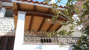 Un edificio con facciata in pietra, travi in legno e ringhiera in metallo.