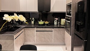 Una cocina moderna con estufa negra, microondas y refrigerador.