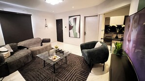 Una sala de estar moderna con un sofá, una mesa de centro y un televisor.