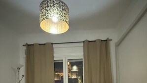 A dining area with a table and chairs, a hanging light fixture, and a view through a window with curtains. - 5 minutes to the centre of Algiers center (Alger Centre)