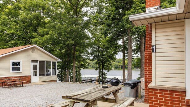 A rustic cabin with a picnic table and a small building with a dock. - Waterfront Cabin for up to 8 (Benton)