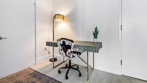 A modern office space with a desk, chair, lamp, and potted plant. - High Rise Condo Water Views Walker's Paradise (Miami)