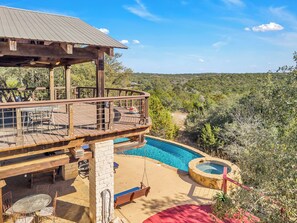 A wooden deck with a pool, a hot tub, and a swing chair. - Hill Country Retreat •Hot Tub, Luxury, Sleeps 14! (Austin)