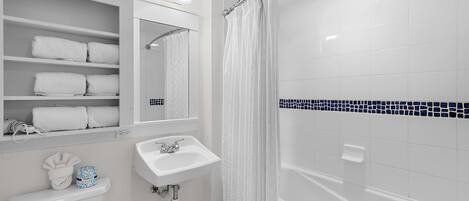 Un baño con inodoro, lavamanos y zona de ducha.