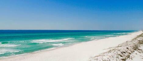 A beach with clear turquoise water and white sand.