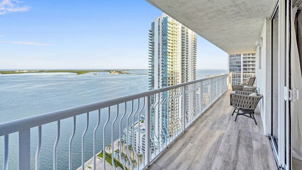 A balcony with a view of the ocean and tall buildings. - Luxurious private unit with parking (Miami)