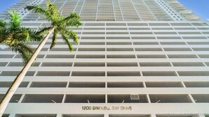 A high-rise building with a grid-like facade and a palm tree in the foreground. - Luxurious private unit with parking (Miami)