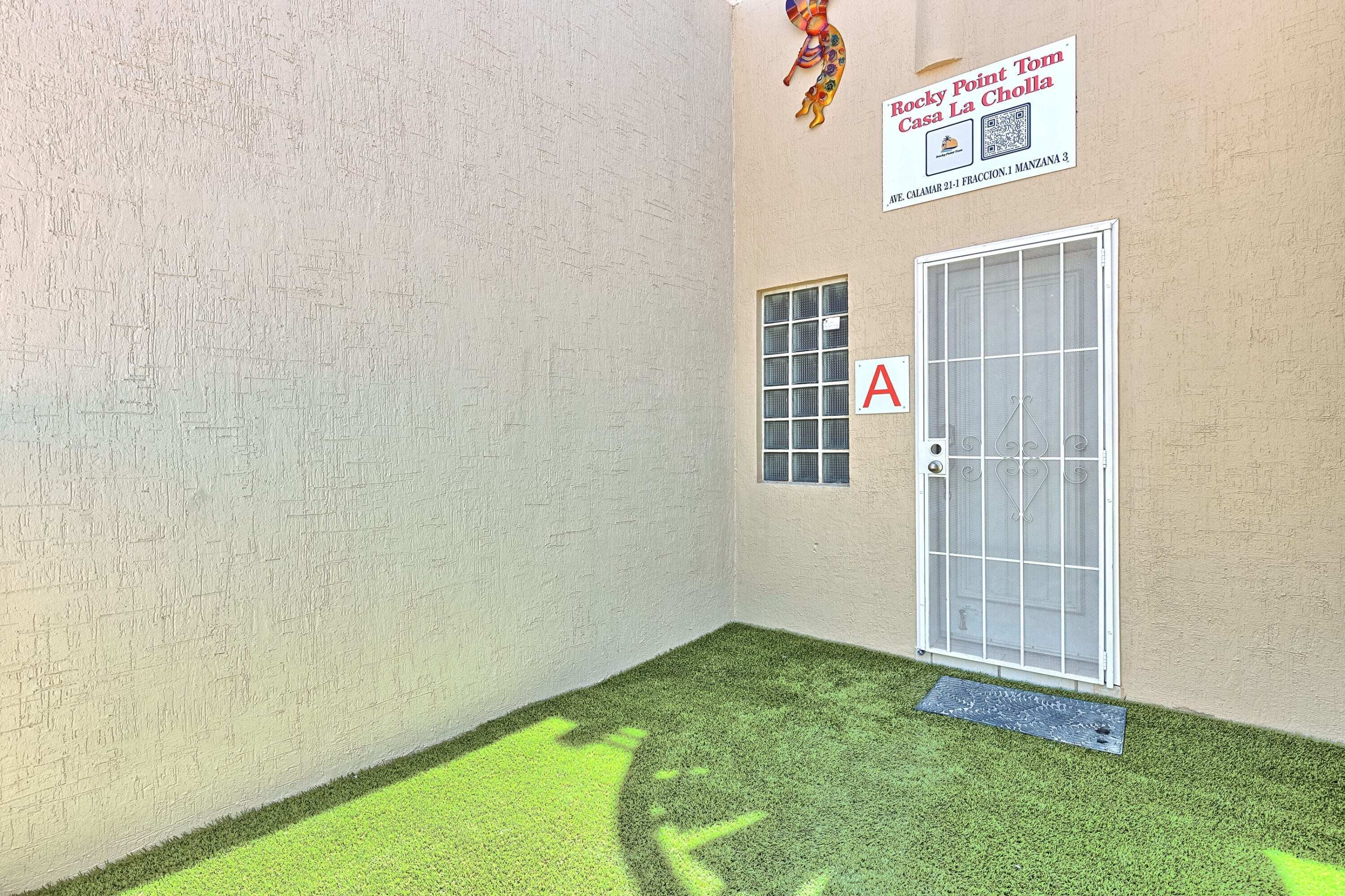 A corner of a room with a door, a window, and a wall-mounted sign.