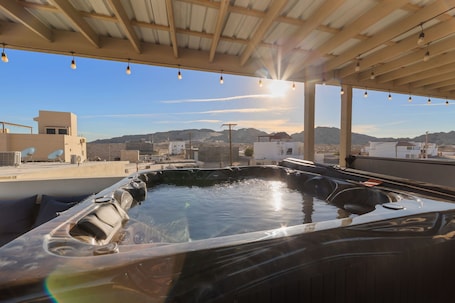 A hot tub area with a view of mountains and a clear sky.