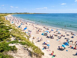 A beach with people sunbathing and swimming, tents, and umbrellas. - Elegant retreat, 10 min. from Newport; game room, fire pit, & huge deck! (Jamestown)