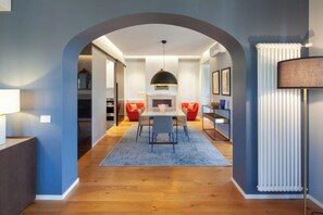 A modern dining area with a central table, red chairs, and a blue carpet. - LUXURY ROME PENTHOUSE WITH ENORMOUS TERRACE AND LANDMARK VIEWS ON VIA DEL CORSO (Roma)