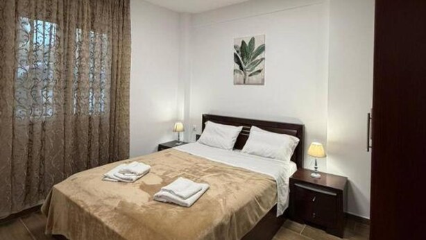 A modern bedroom with a bed, a nightstand, a lamp, and a ceiling light. - Le Grace Urban Retreat Near Near Citycenter Sea (Kalamaria)