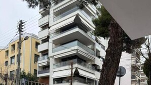 A modern apartment building with multiple balconies, a tiled terrace, and parked cars. - Le Grace Urban Retreat Near Near Citycenter Sea (Kalamaria)