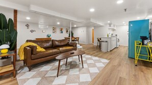 A modern living room with a brown leather sofa, a wooden coffee table, and a patterned rug. - Welcoming Home near Downtown Boise (Boise)