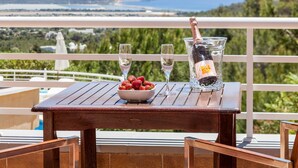 A wooden table with a bowl of strawberries and two glasses of champagne on a balcony with a scenic view. - Teresa Fontalba_Ses Casetes (Sant Jordi de Ses Sali)