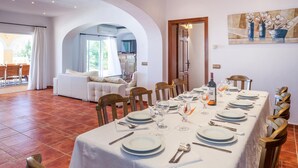 A dining area with a long table set for a meal, surrounded by wooden chairs. - Teresa Fontalba_Ses Casetes (Sant Jordi de Ses Sali)