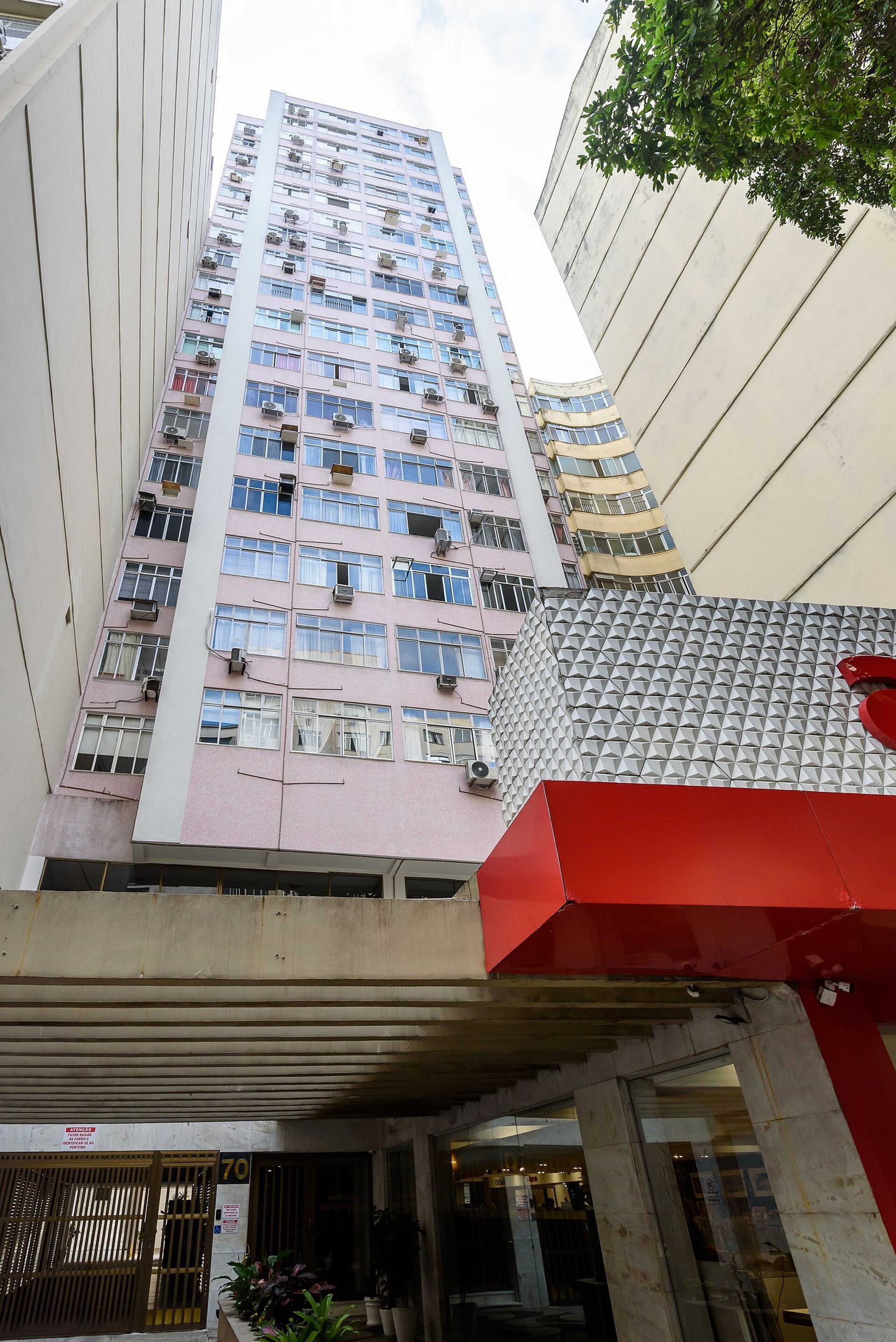 A multi-story building with a modern architectural design, featuring a prominent red structure in the foreground.