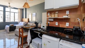 Cozinha moderna com micro-ondas, fogão e armários brancos.
