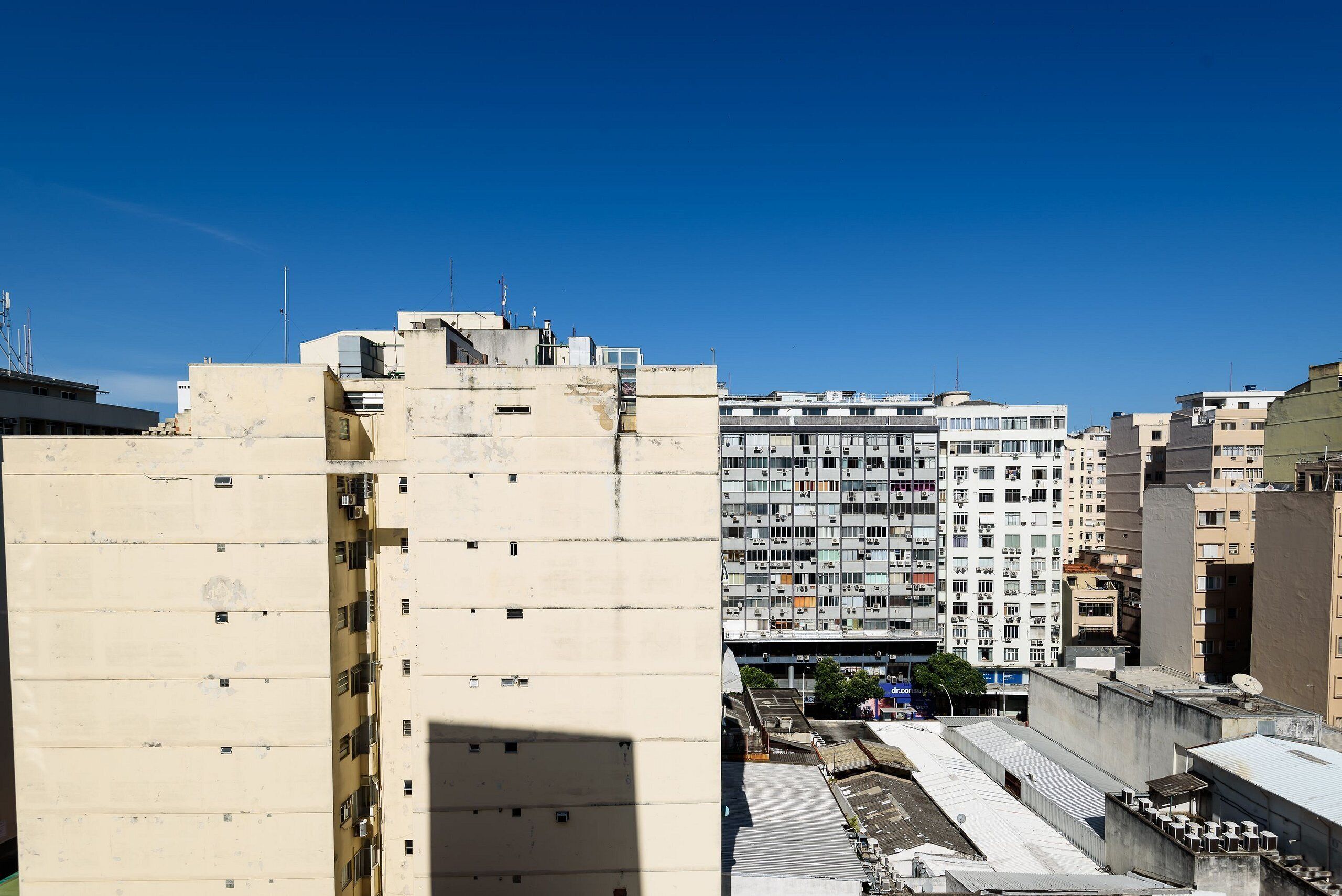 A high-rise building with multiple floors, large windows, and a flat roof.