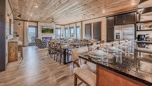 A spacious dining area with wooden floors and a large island counter.
