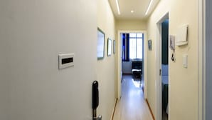 Ein Flur mit einer Tür, einem Lichtschalter und einem an der Wand montierten Thermostat.