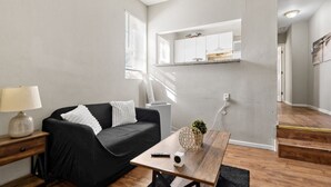 Ein modernes Wohnzimmer mit einem schwarzen Sofa, einem Holztisch und einer Lampe.