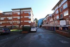 A residential street with red brick buildings, a private car park, and a Moss House Close sign. - 2 Bed Smart Stay in Five Ways (Birmingham)