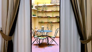 Une terrasse extérieure avec une table et des chaises, entourée de rideaux.
