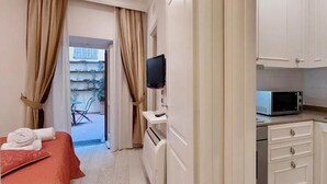 Une chambre d’hôtel équipée d’un lit, d’une télévision, d’un four à micro-ondes et d’une kitchenette.