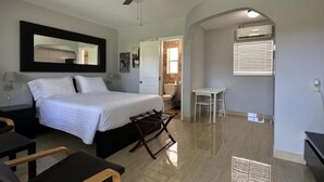 Ein Schlafzimmer mit Bett, Deckenventilator, Tisch und Stuhl.