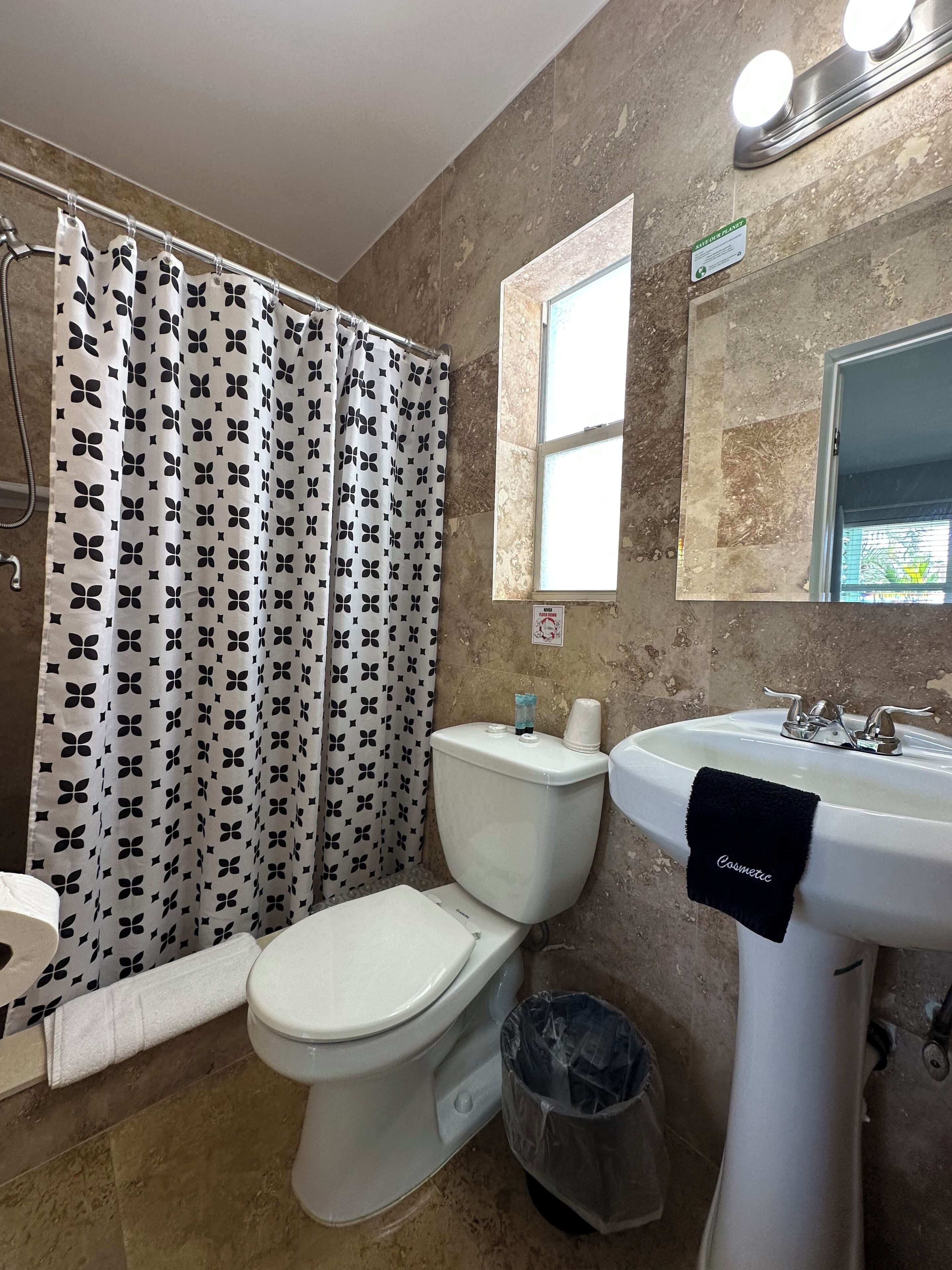 Un baño con inodoro, lavabo y cortina de ducha.