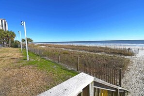 A beach with a wooden walkway, a fence, and a clear view of the ocean. - Remodeled and Decorated 1BR Direct Oceanfront View (Myrtle Beach)