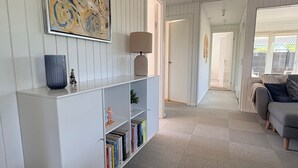 A modern living room with a white bookshelf, a lamp, and a couch. - A sanctuary by the water – Vejlby Fed (Middelfart)