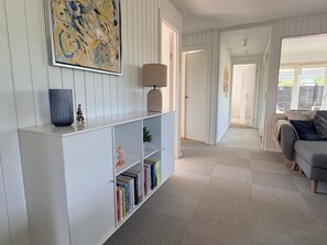Ein modernes Wohnzimmer mit einem weißen Bücherregal, einer Lampe und einem Sofa.