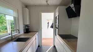 A modern kitchen with a sink, countertop, and a view to the outside. - A sanctuary by the water – Vejlby Fed (Middelfart)