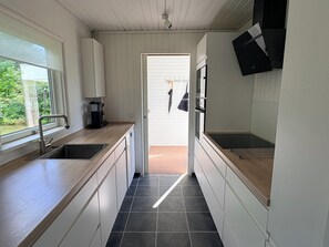 Eine moderne Küche mit Spüle, Arbeitsplatte und Blick ins Freie.