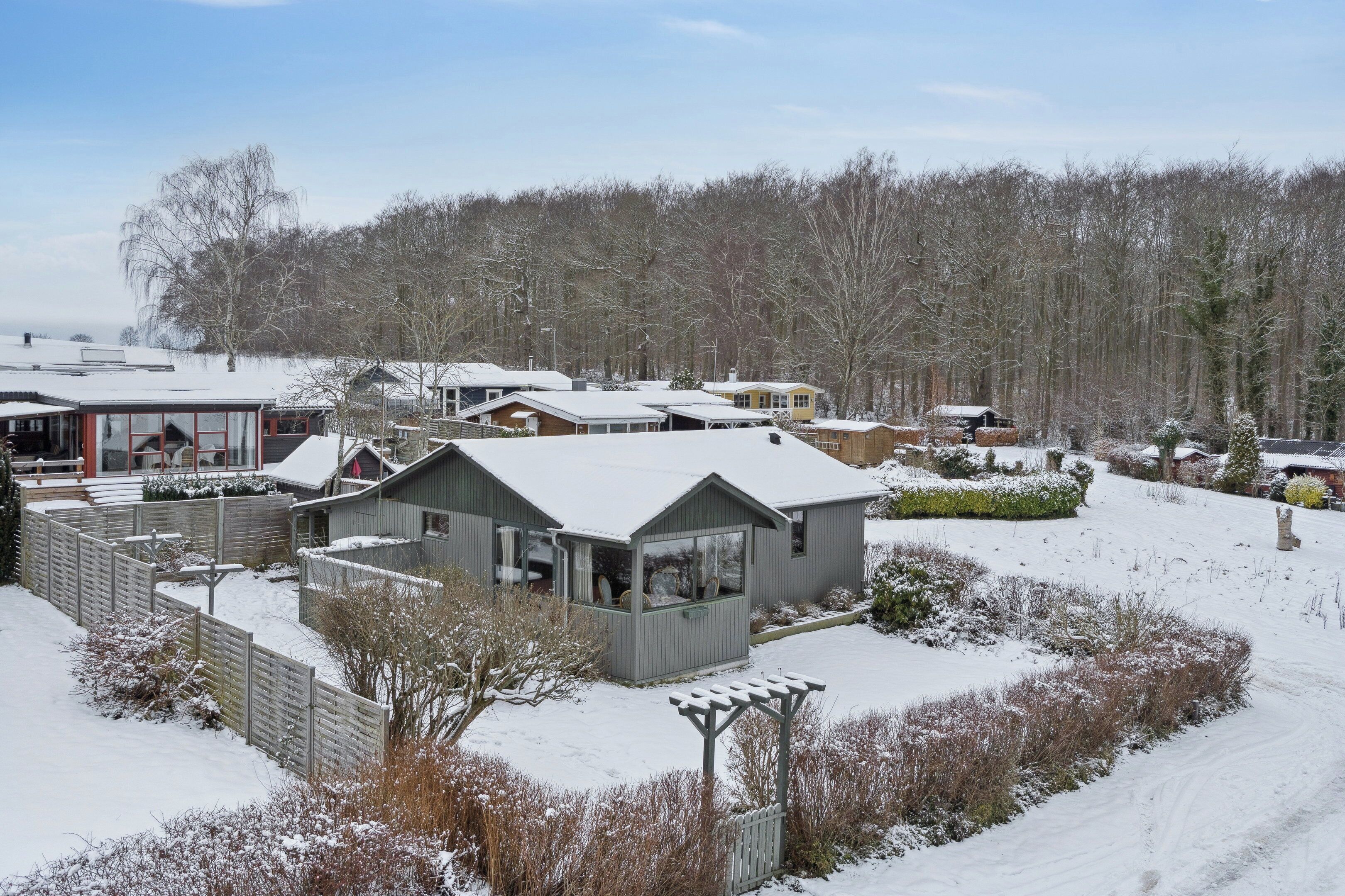 Un quartiere residenziale con diverse case, un cortile recintato e un paesaggio innevato.
