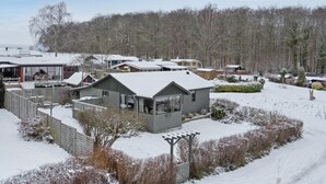 Un quartier résidentiel avec plusieurs maisons, une cour clôturée et un paysage enneigé.