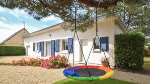 Una casa con un trampolín en el jardín delantero.
